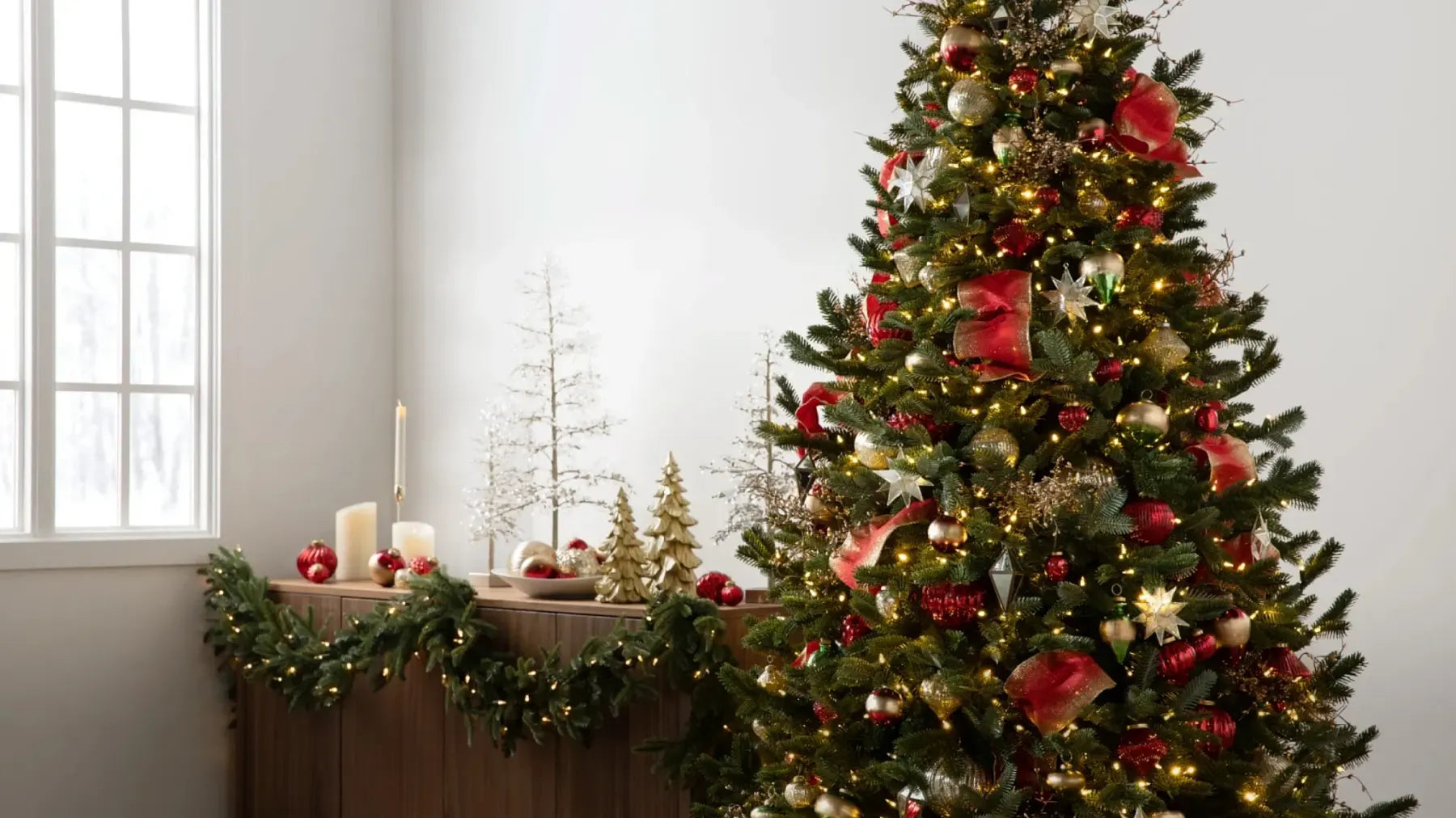 Árvore de Natal decorada com laços e enfeites vermelhos em uma sala